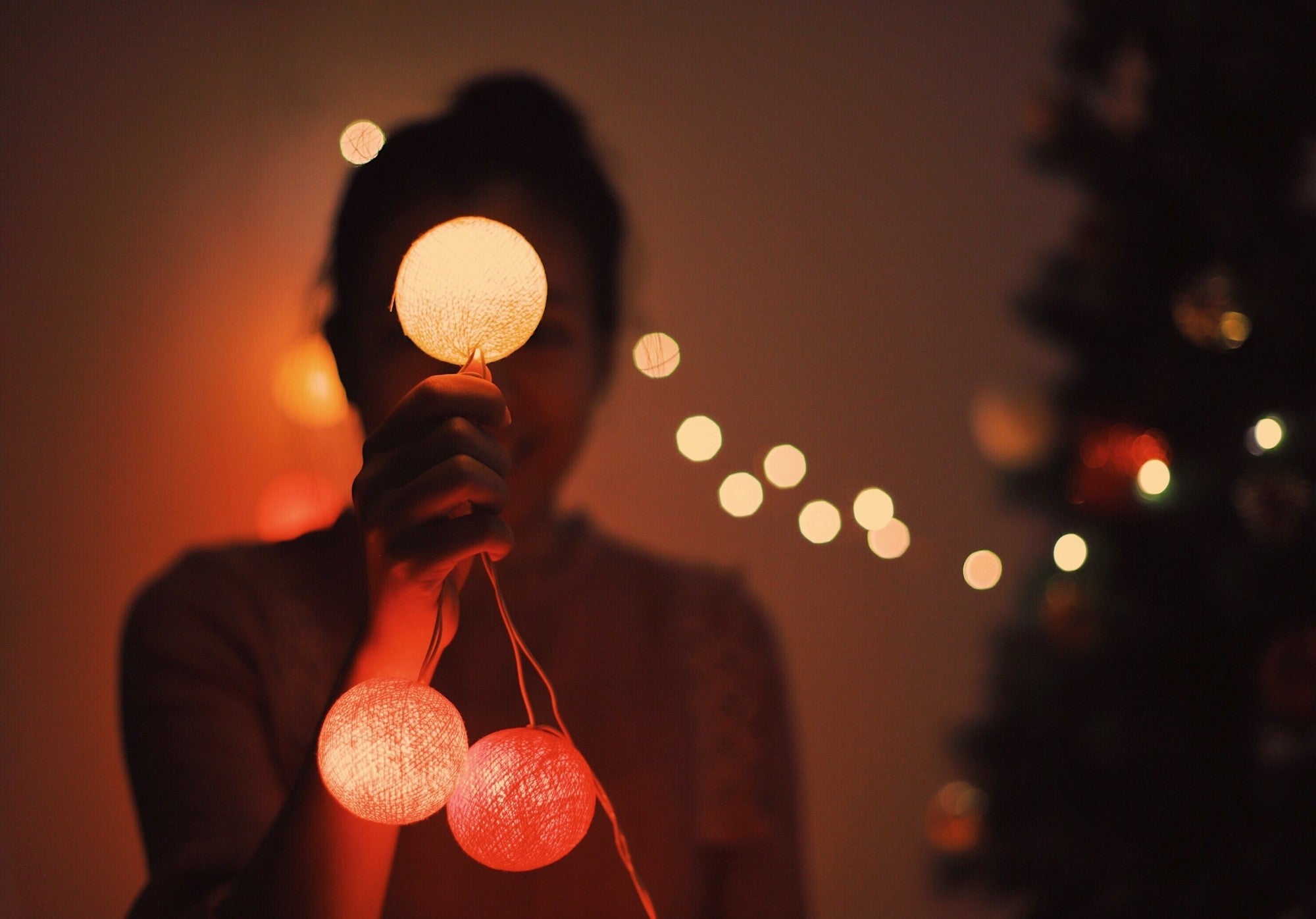 Frau mit Lichterkette – magische Beleuchtung und gemütliche Stimmung im Wohnzimmer