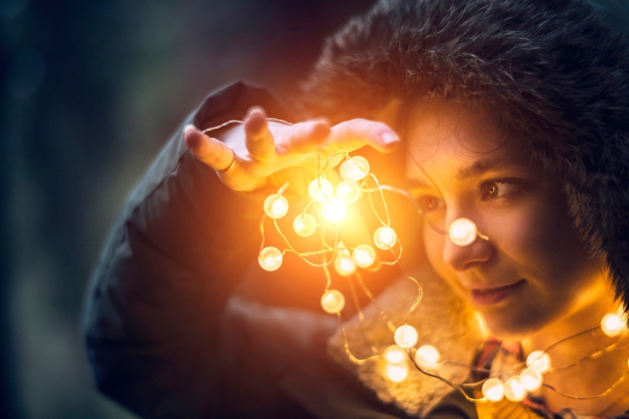 Mädchen mit Lichterkette im Winter