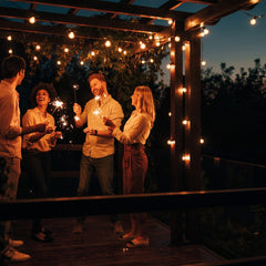 Außenlichterketten auf Terrasse bei Abenddämmerung, warme Lichter schaffen festliche Stimmung.