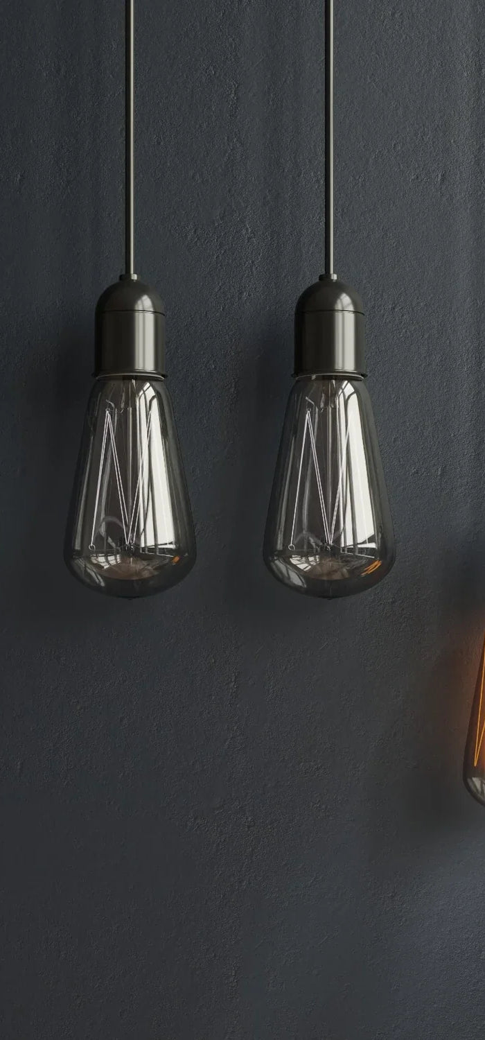 Industrielle Hängeleuchten mit LED-Filament im Vintage-Stil, eine Lampe warm beleuchtet vor dunkler Wand