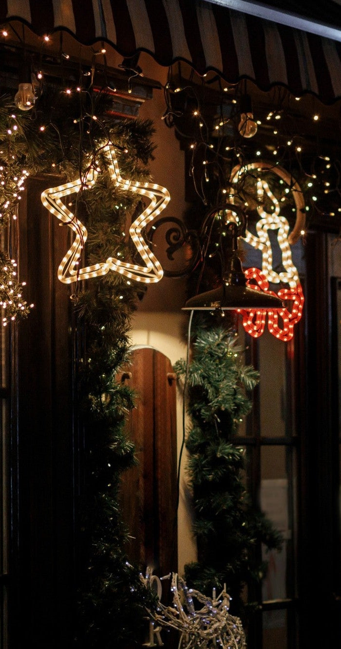 Stilvolle Weihnachtsbeleuchtung für den Außenbereich mit warmweißem Licht an einer festlich dekorierten Hausfassade
