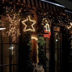 Stilvolle Weihnachtsbeleuchtung für den Außenbereich mit warmweißem Licht an einer festlich dekorierten Hausfassade