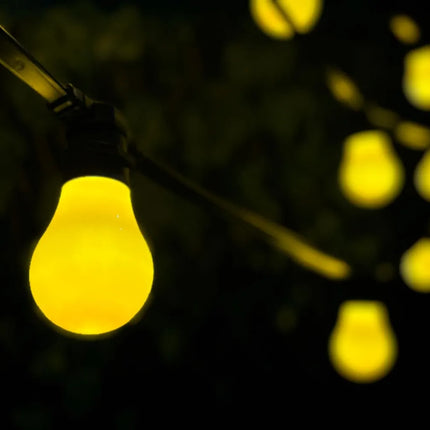 Lichterkette mit schwarzem Kabel und gelben LED-Leuchtmitteln im Außenbereich