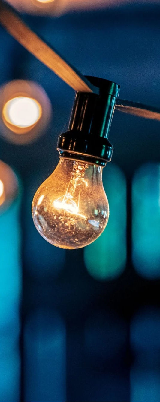 Außenlichterkette mit warmem Stimmungslicht auf Terrasse bei Abenddämmerung